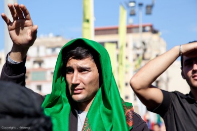 A man raises his hand in support for Nisrallah as he speaks to crowds at Ashura in Beirut